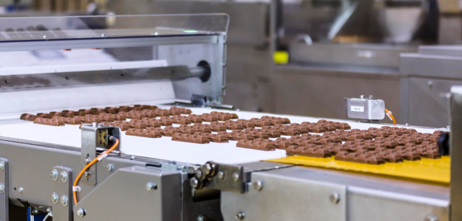 Línea de producción industrial de chocolates en cinta transportadora