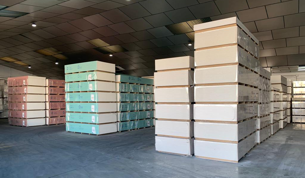 Almacén de materiales de construcción con placas de pladur apiladas en palets